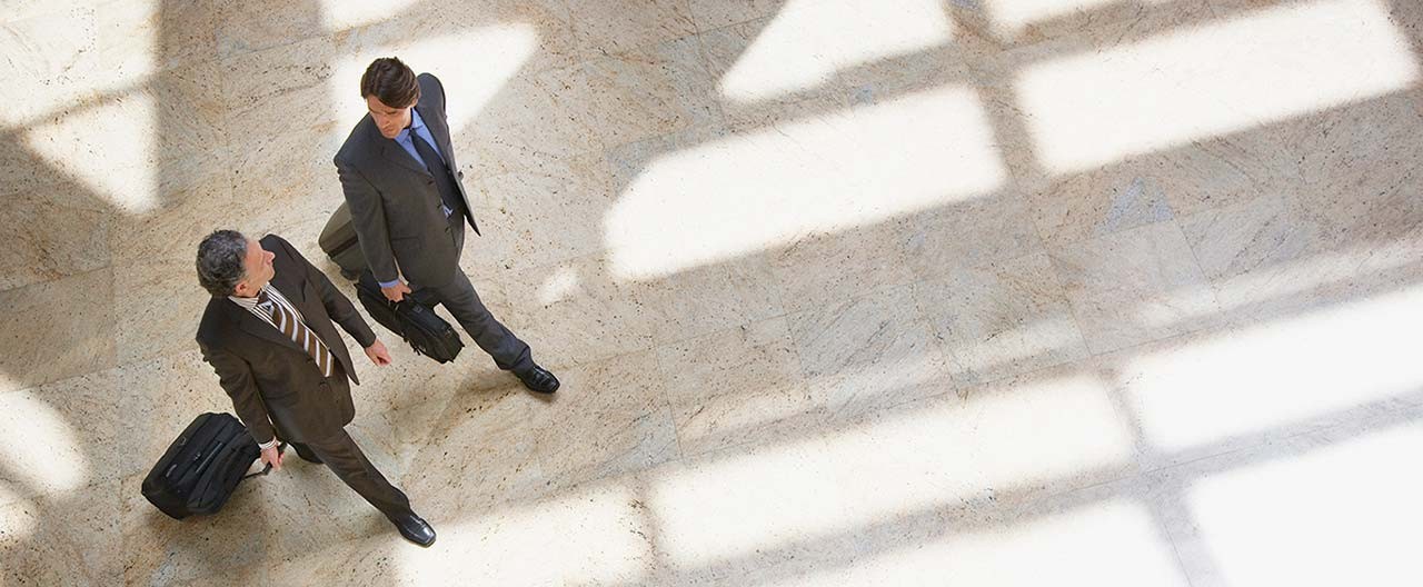 business men pulling rolling suitcases