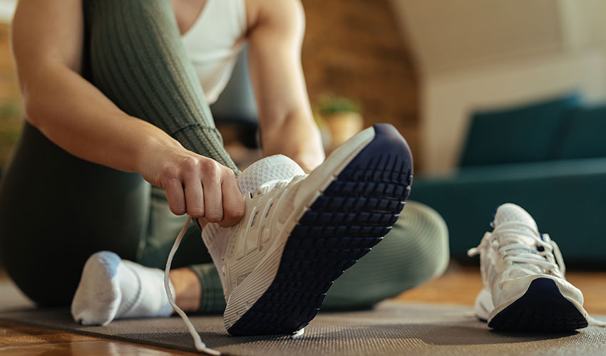 woman lacing her sneakers