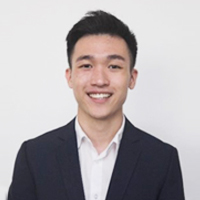 a man wearing a suit and tie smiling at the camera