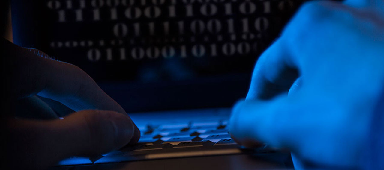 hand typing on laptop blue filter