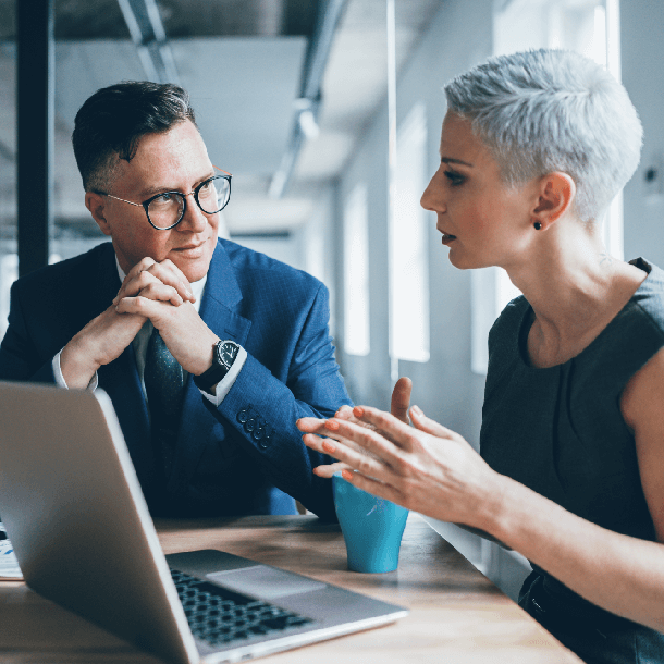 two people discussing over laptop