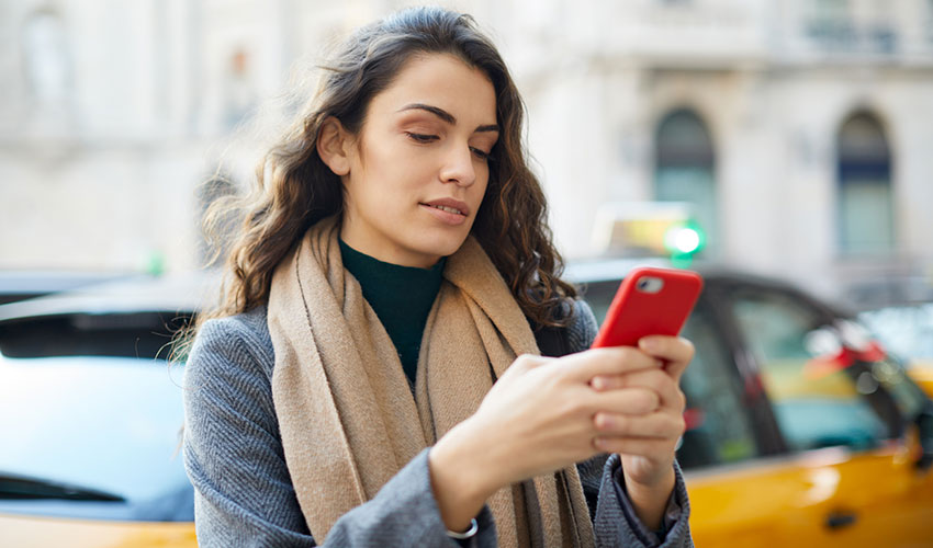 woman texting on city street