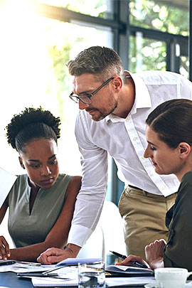 women and man looking at documents