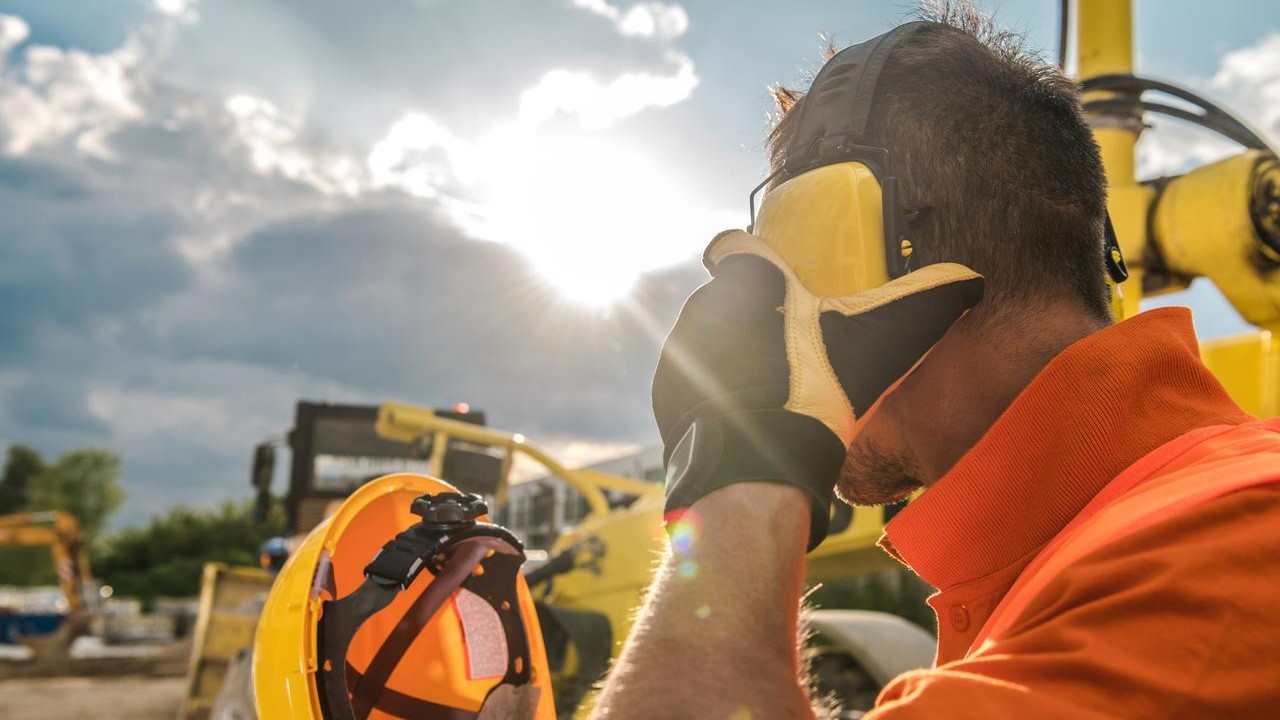 construction worker putting on noise reducing headphones