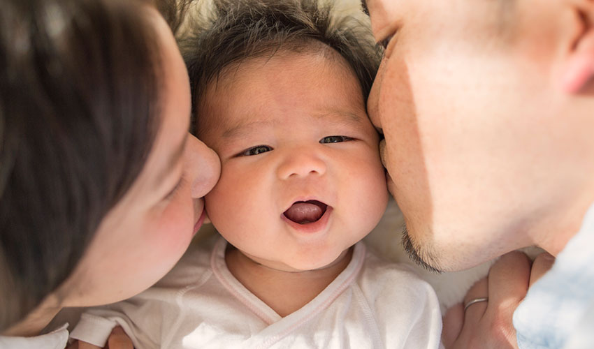 family kissing baby