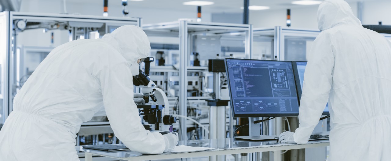 scientists looking through microscope in life sciences cleanroom