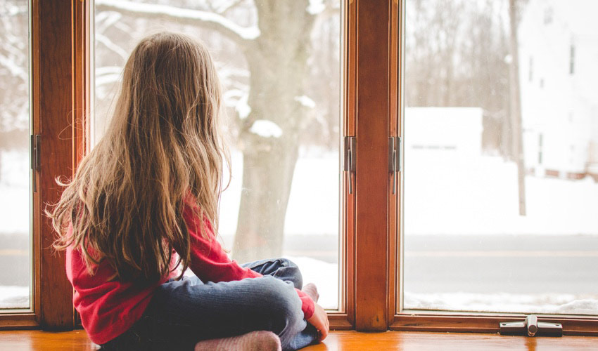 little girl watching snow fall