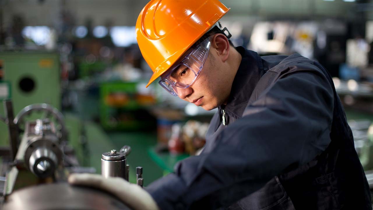 technicien en uniforme et casque de sécurité travaillant sur des machines