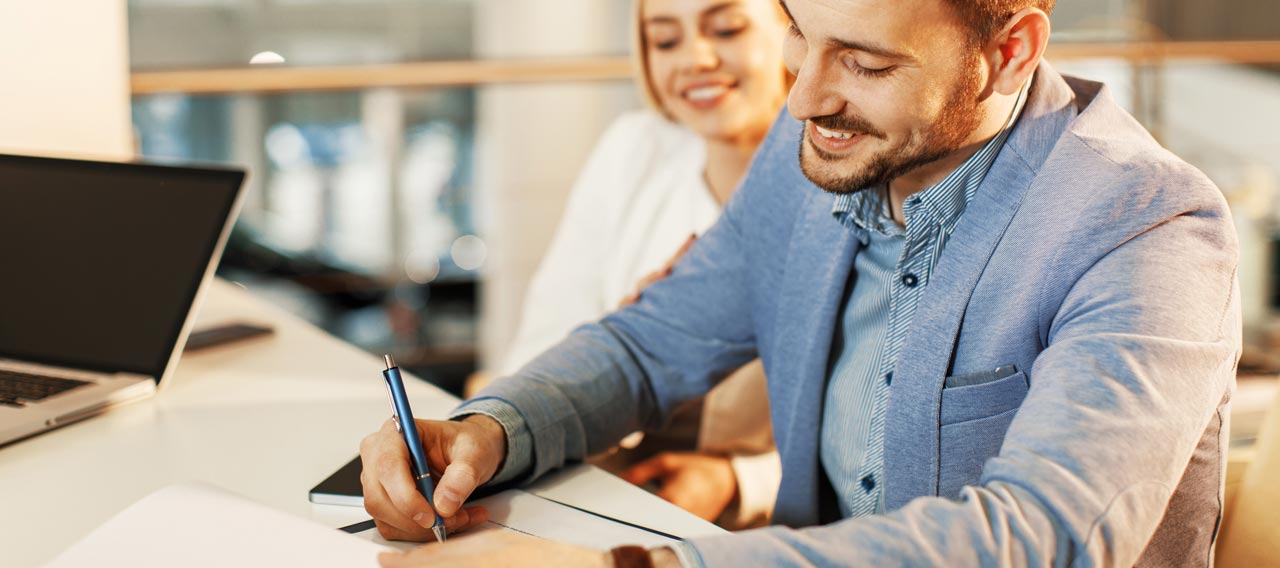 man signing a contract