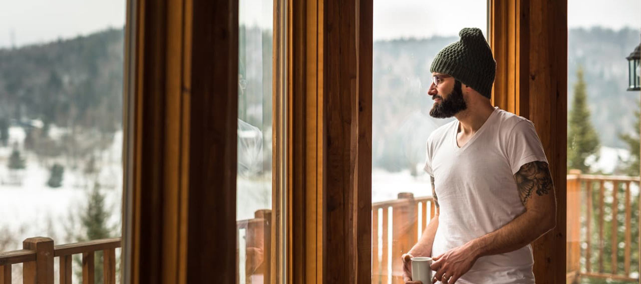 man watching the snowy view inside