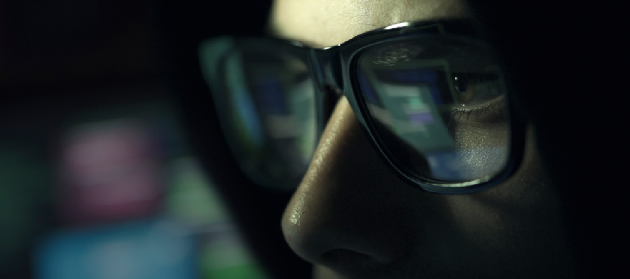 man with glasses in the dark