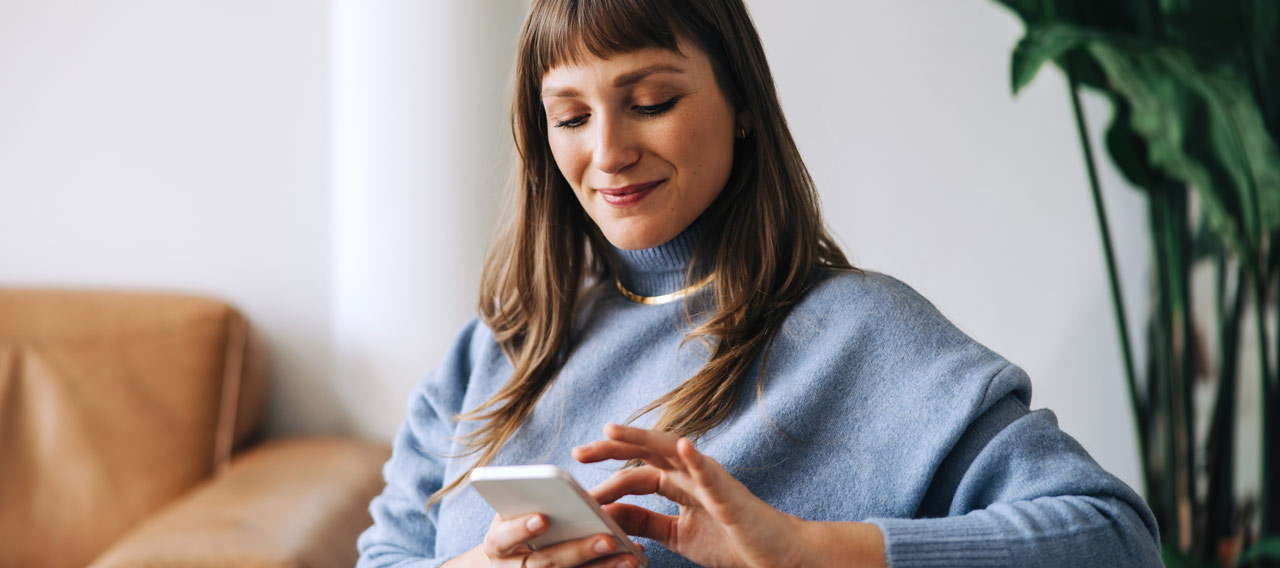 woman using her phone, smiling