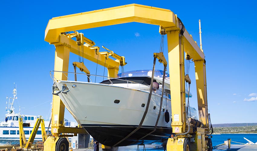 boat hoisted by cranes