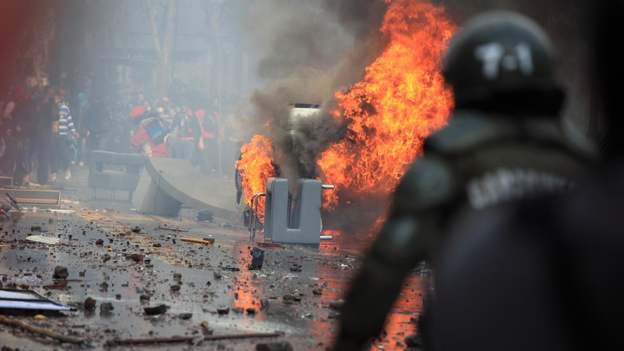 une voiture renversée et en feu lors d'une manifestation