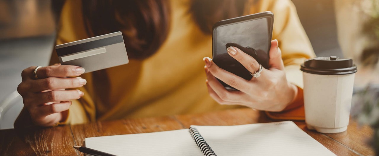 woman holding card and phone