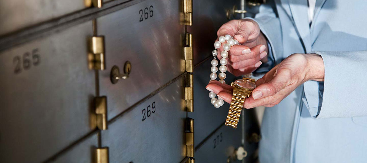 woman putting away jewelry in safe