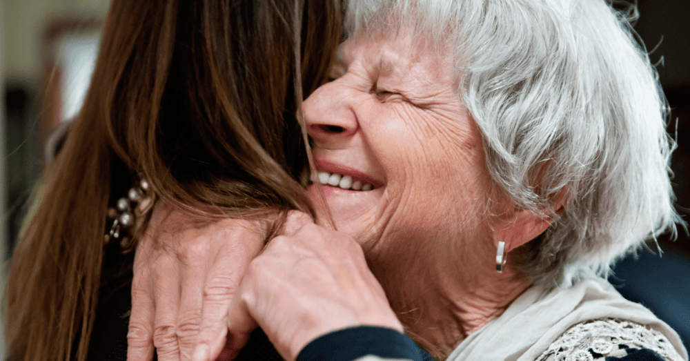 elderly mother hugging daughter