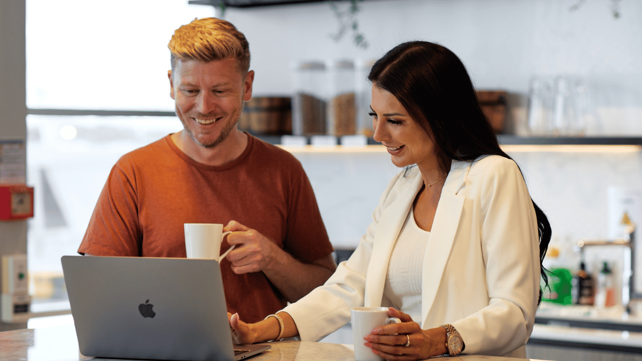 man working with a woman on a laptop